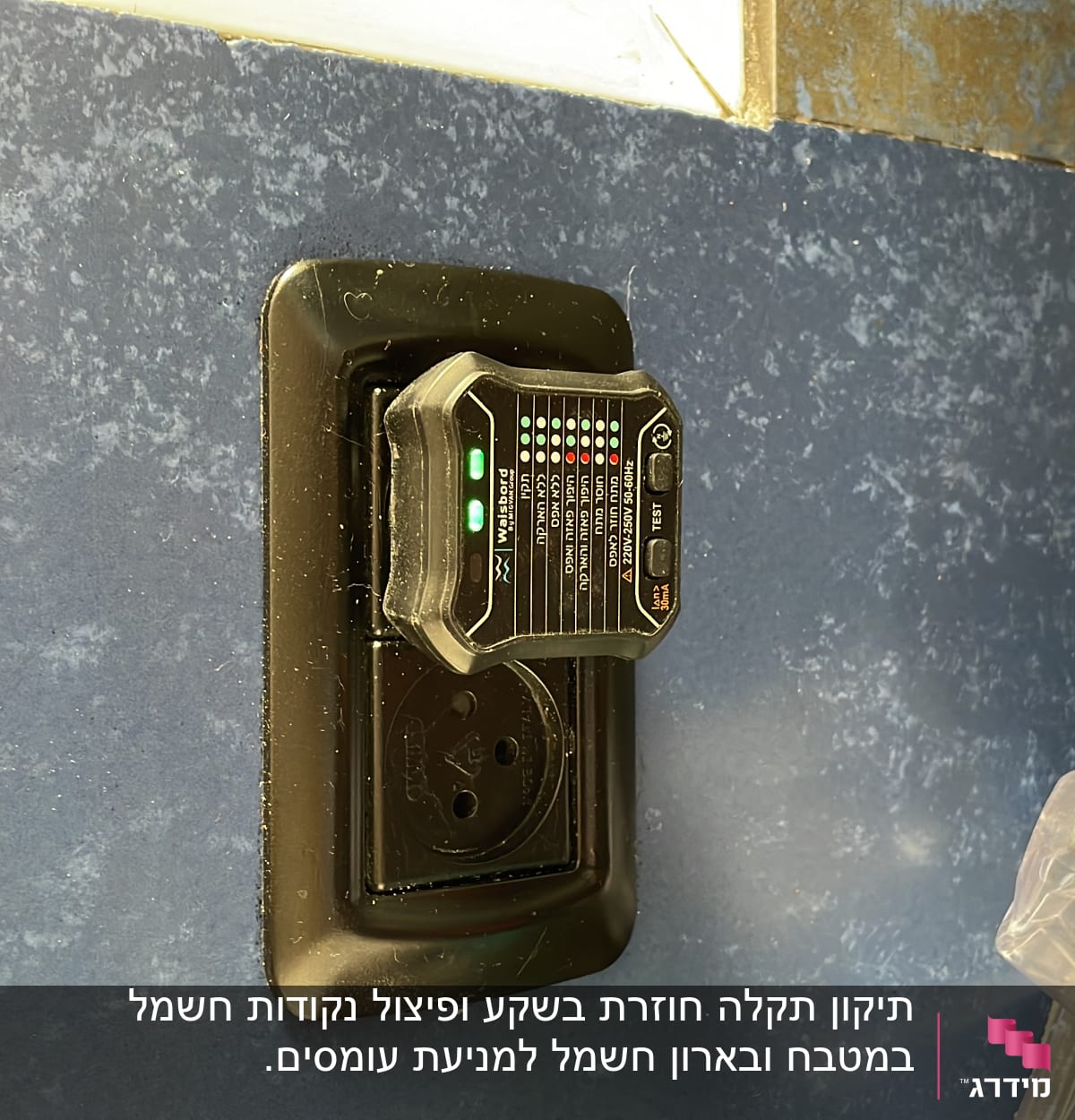 בודק שקעים חשמלי מחובר לשקע בקיר כחול